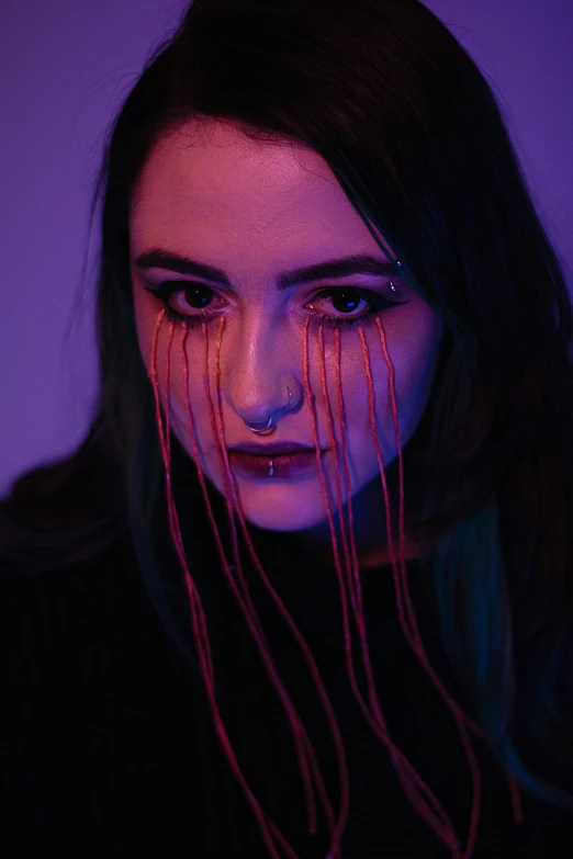 woman with pink hair, black eyes and dripping red yarn