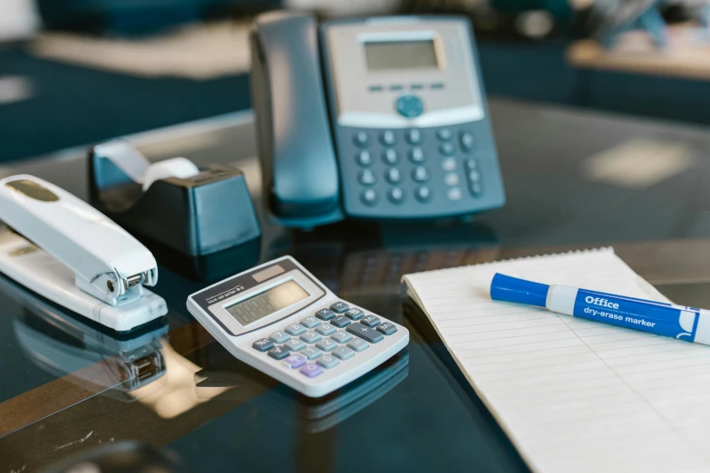 a table top with some cell phones and a pen