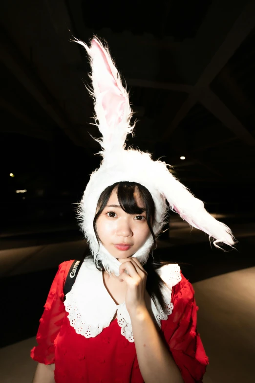 a woman wearing a red shirt and white bunny ears hat