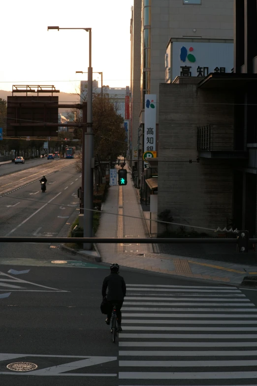 there is a bicyclist at the crosswalk and car