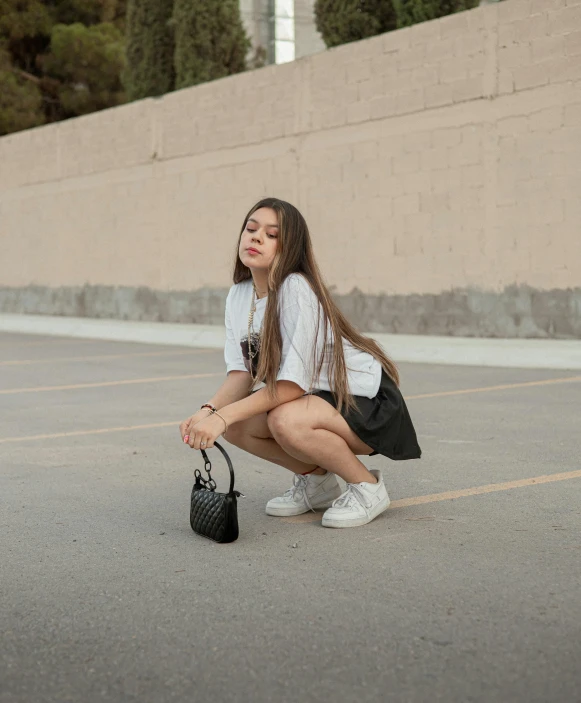 the young woman is sitting in the parking lot