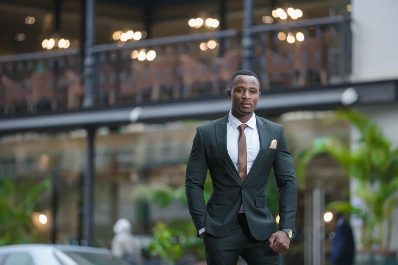 the man is dressed in all green and wearing a brown tie