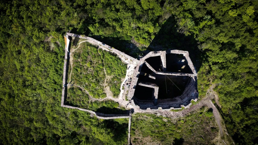 an aerial view of the remains of an old castle in the middle of a forest