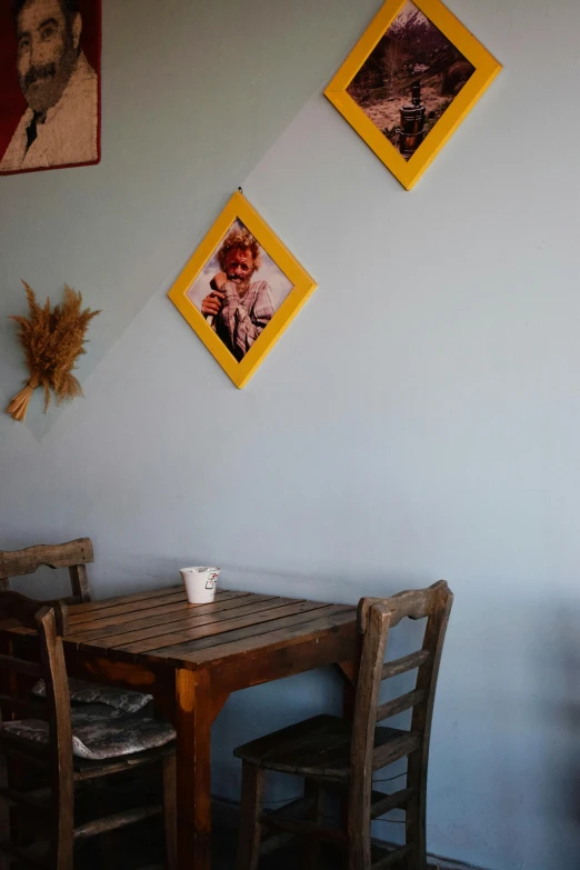 a table with two chairs and pictures on the wall