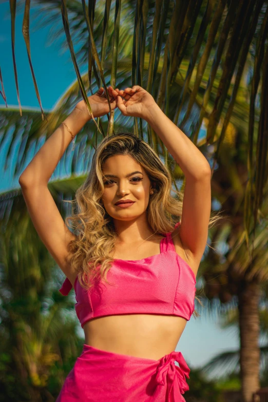 a woman in a  pink skirt and top posing