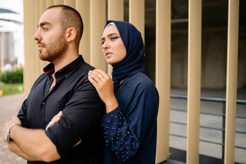 a man standing next to a woman in black