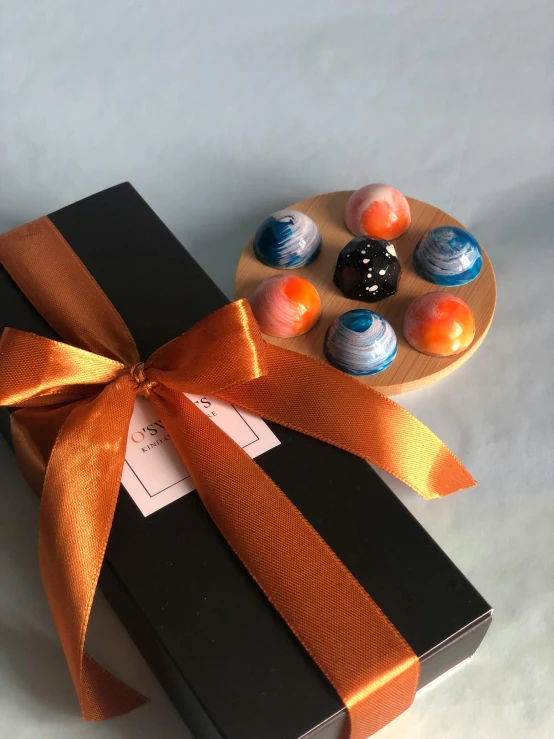 a package of marbles tied with a orange ribbon