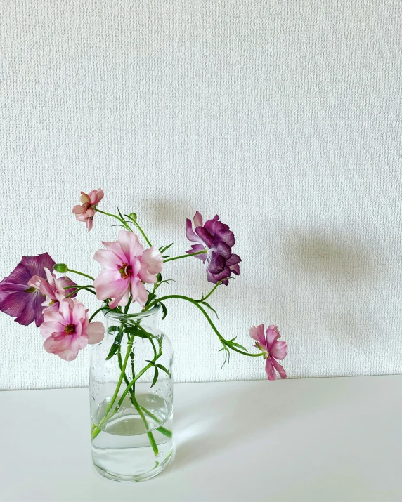 a glass vase filled with water and purple flowers