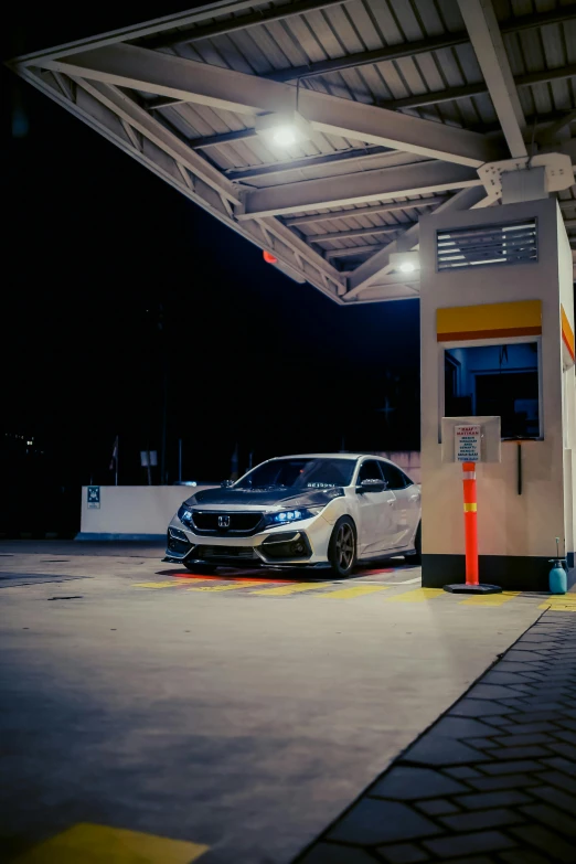 a car is parked at a station with its hood up