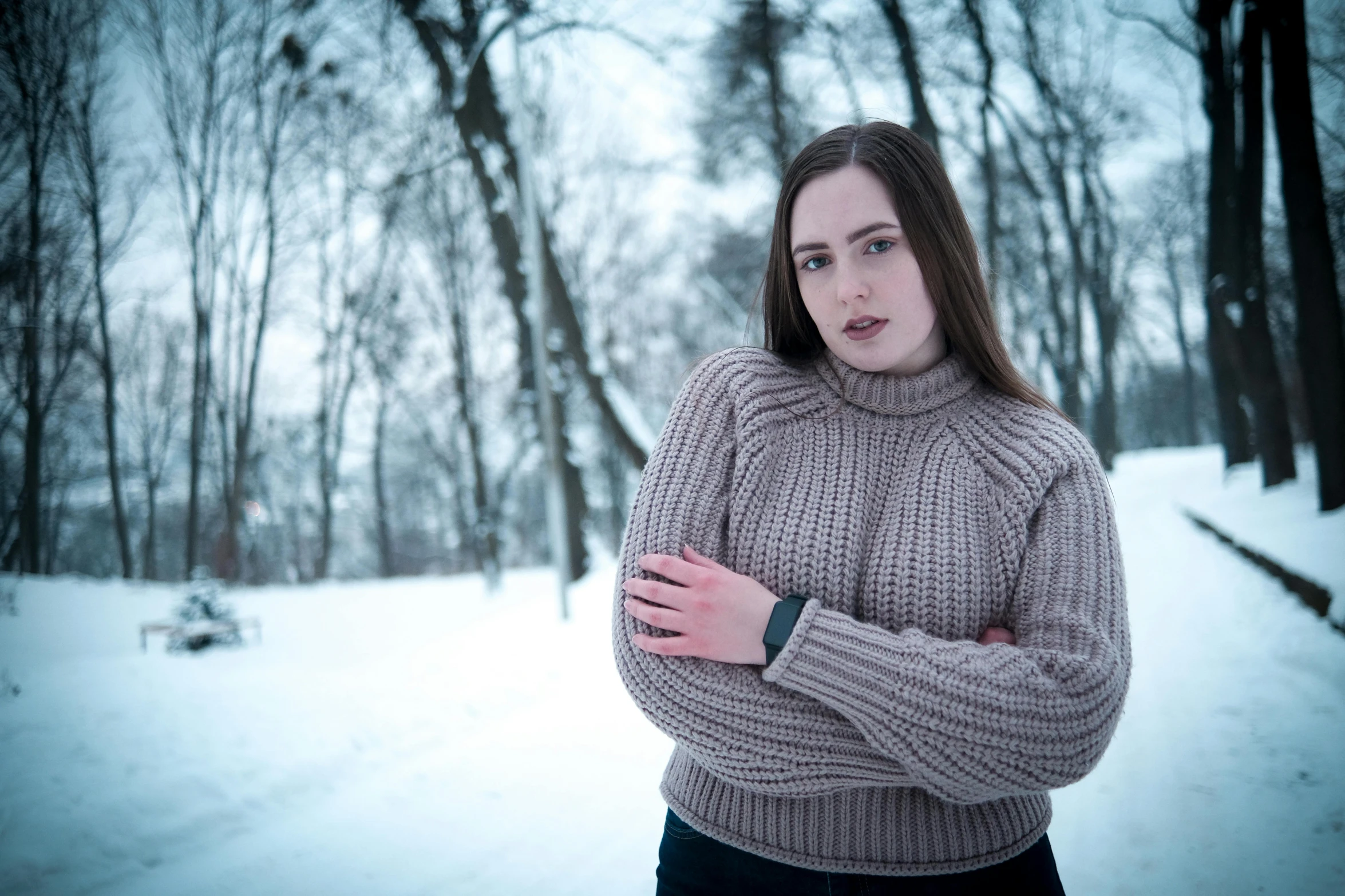 a young woman standing in front of a snowy path