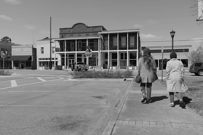 two women walk together on the sidewalk