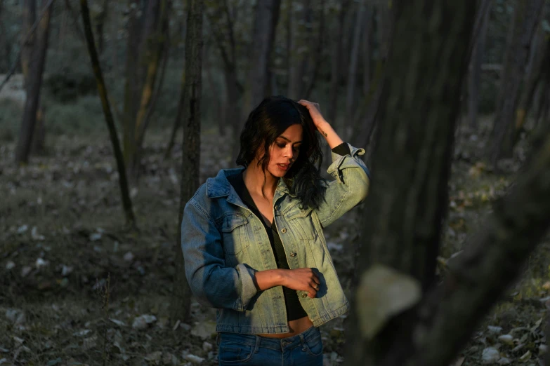 a woman is standing outside in the woods