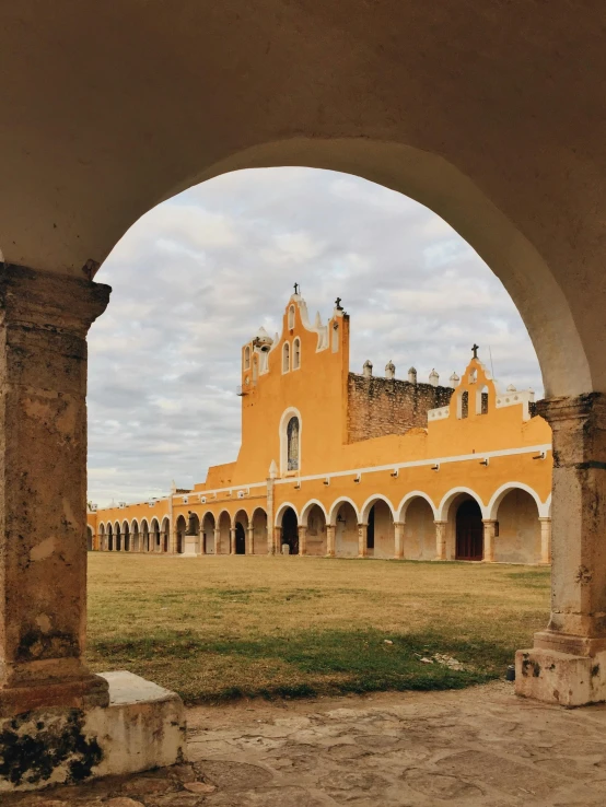 the building is yellow and has an open arch