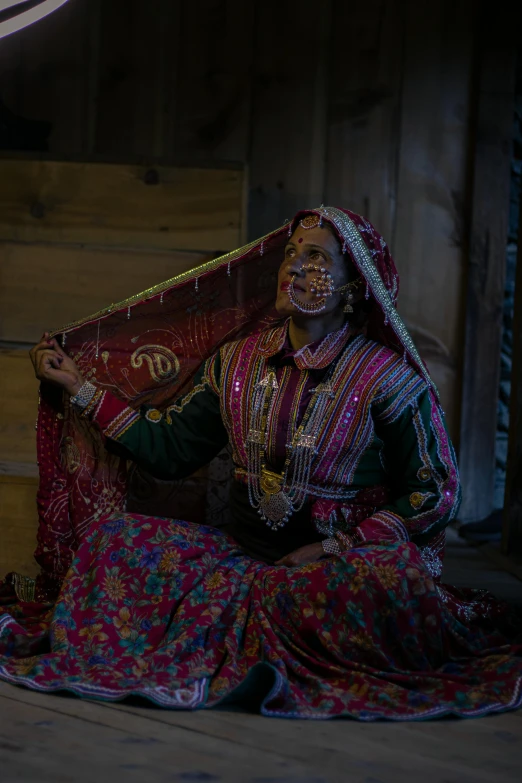 a woman is dressed in folk garb while sitting on stairs