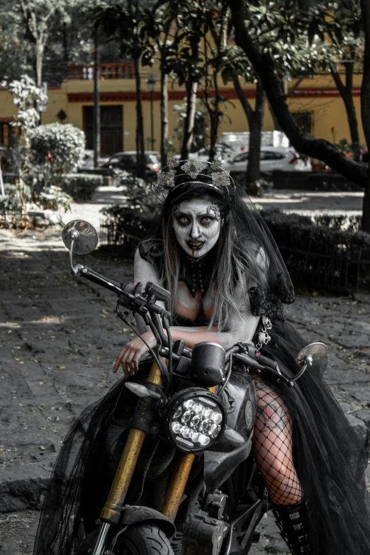 a skeleton - themed lady is posing on a motorcycle