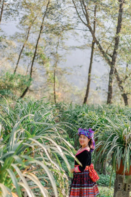 a  with a purple bandana and plaid skirt standing in the forest