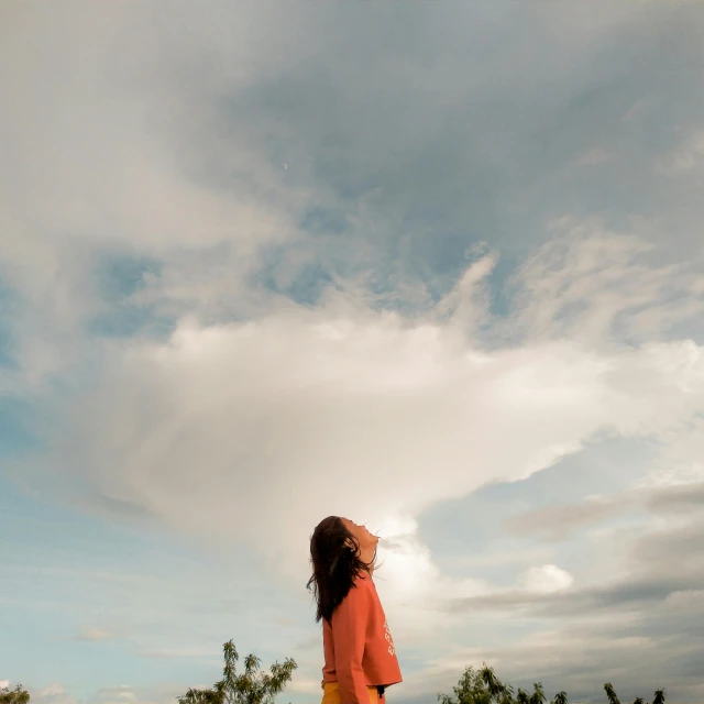 woman flying kite in open field of green grass