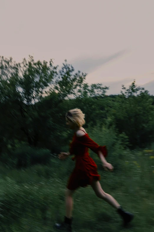 a girl is running through the grass in a field