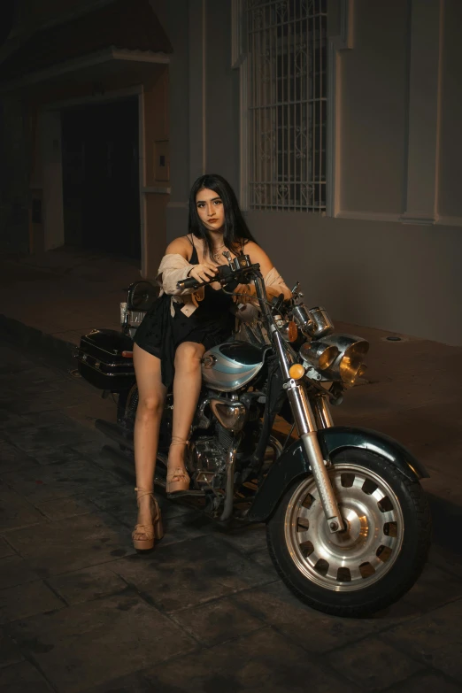 a woman sits on top of a motorcycle