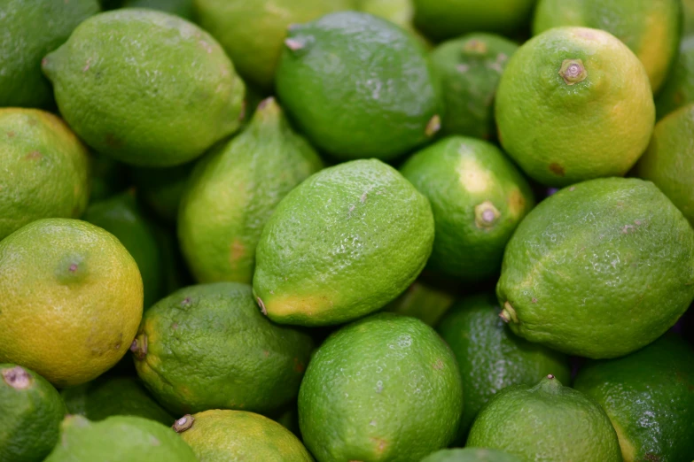a large pile of limes on display for sale