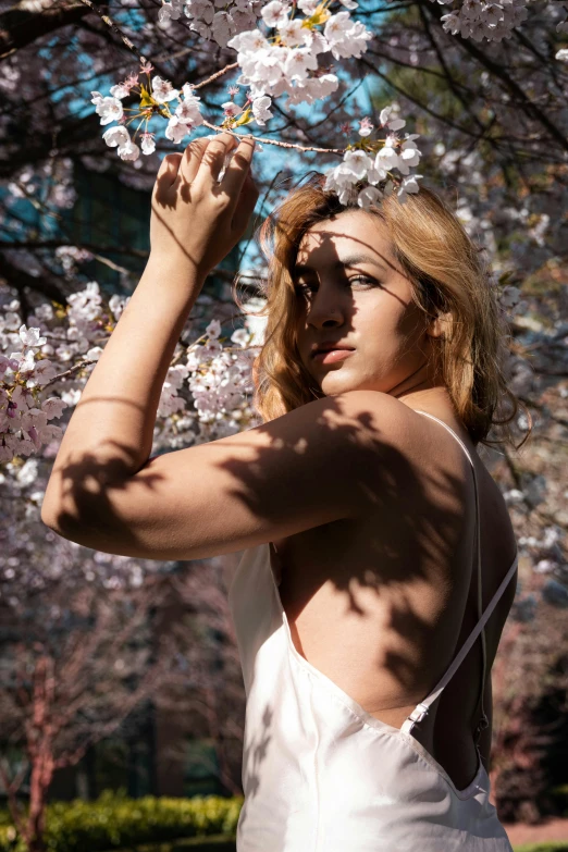 a woman is in a white dress with flowers around her neck