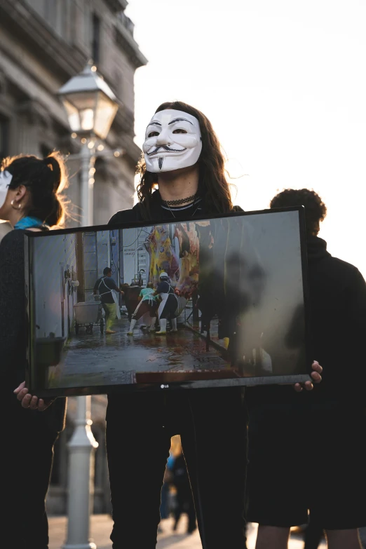 people wearing masks holding a large piece of artwork