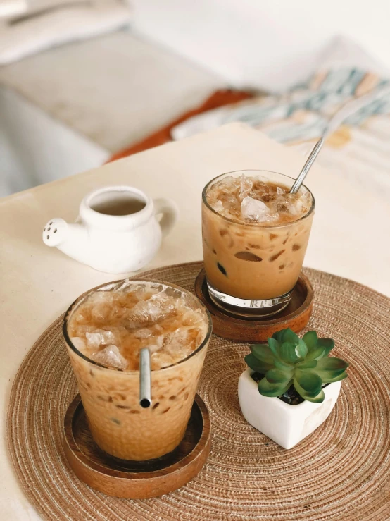 two glasses of iced drink on plate with coffee mug