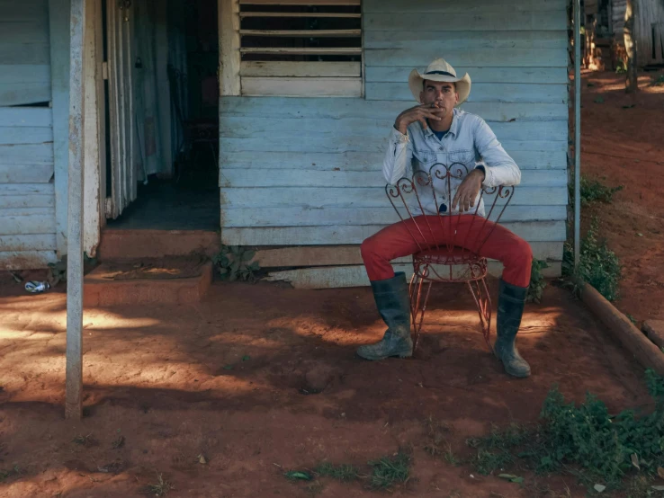 an older person poses for a pograph by their old chair