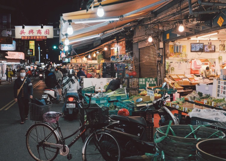 a crowded market with bicycles in front