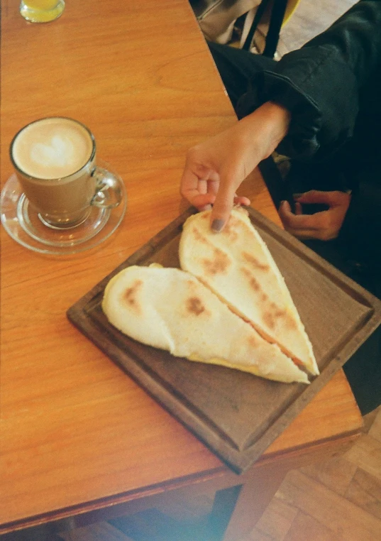two pieces of pita bread on a tray on a wooden table