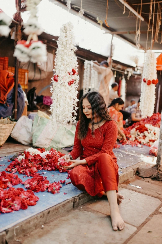 woman sitting on a floor with red flowers