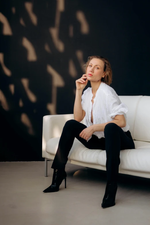 a woman sitting on top of a white couch