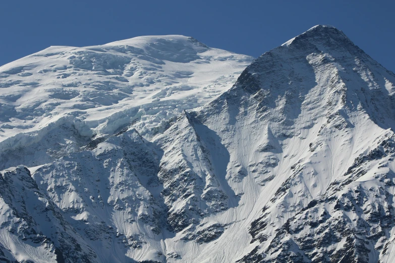 a snowy mountain range under a blue sky