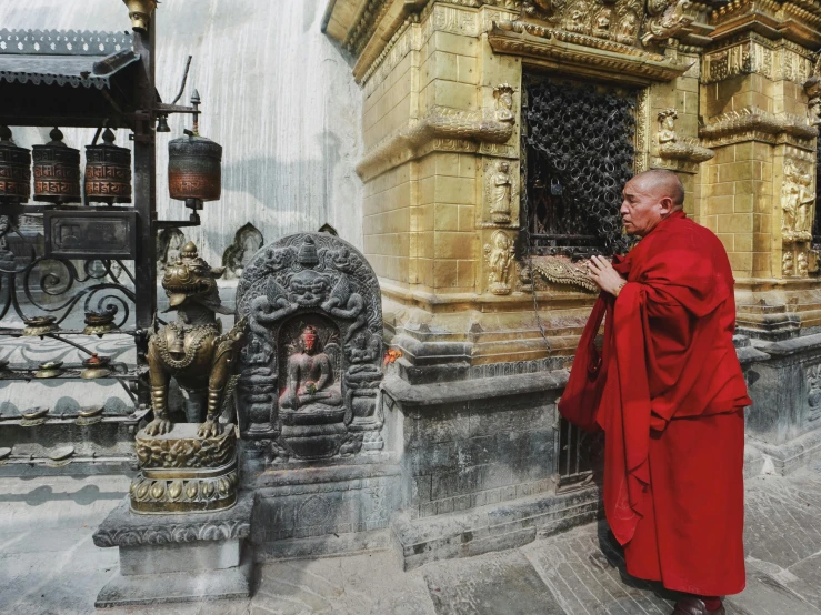 a person is standing near a buddha statue