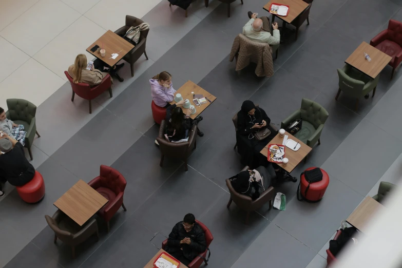 several people sitting at tables in a large room