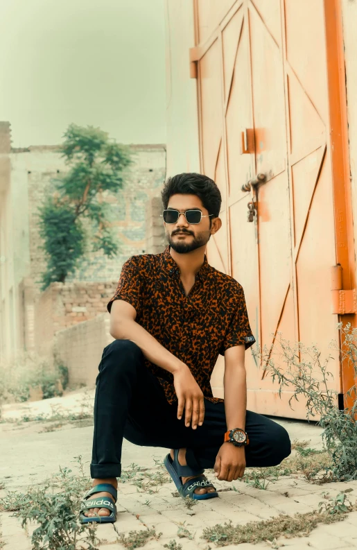 a man sitting in front of a door with no one wearing sunglasses