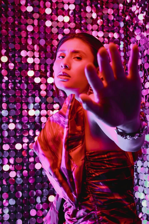 a woman posing in a purple light with a pink and blue background