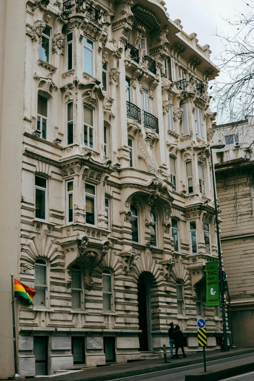 the front of a large building with a rainbow flag hanging from it's sides