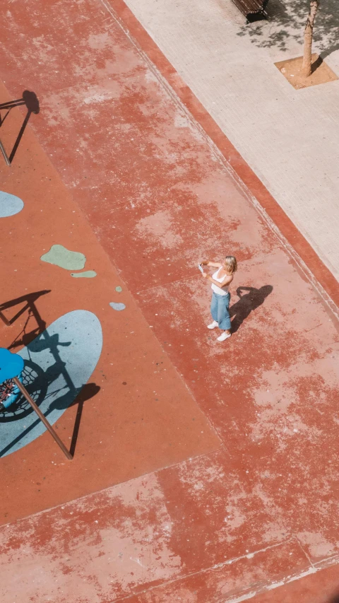 small child holding his arms up and pointing with two hands on a park bench