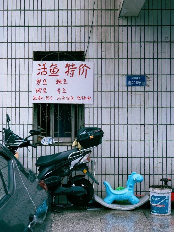 scooter with motorbike attached to front parked in front of building