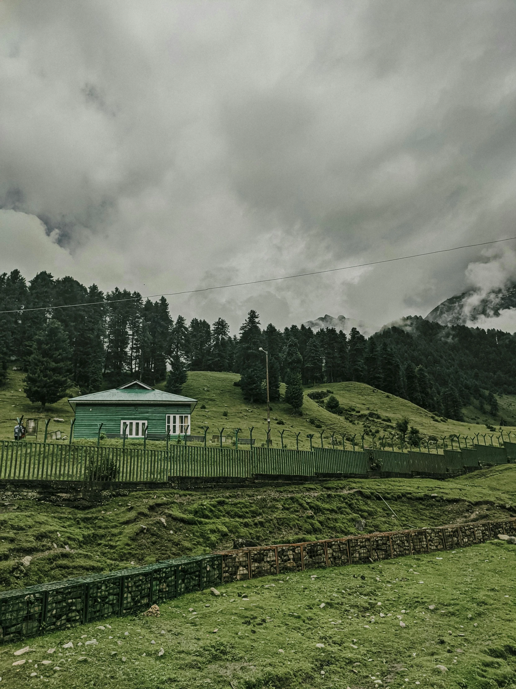 a green grassy field with some small buildings in the background