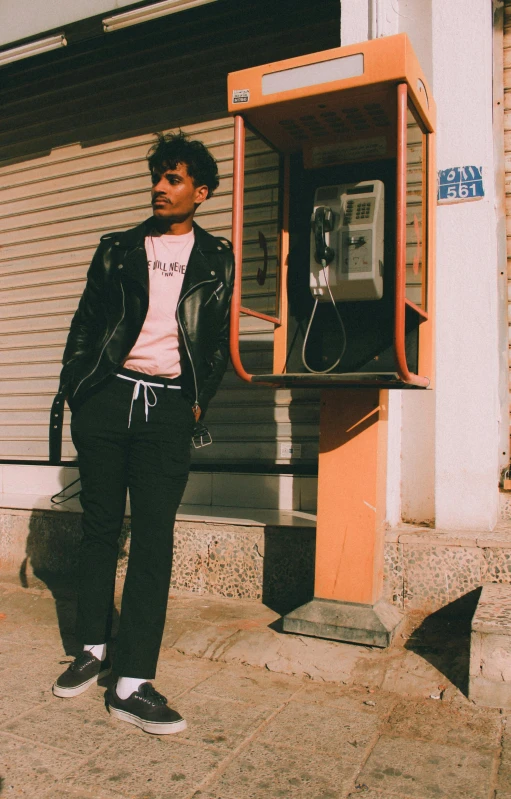 there is an image of man standing next to the telephone booth