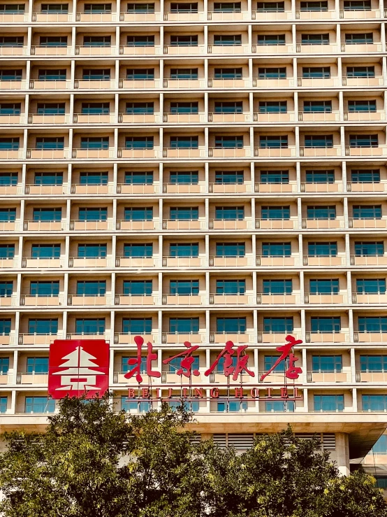 a building with several stories and large red signs on it