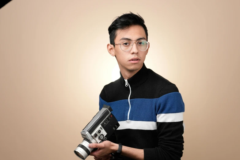 a man holding up an old fashioned camera