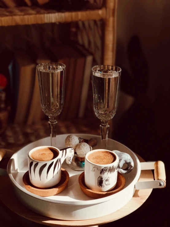 two drinks are sitting on the table with champagne flutes