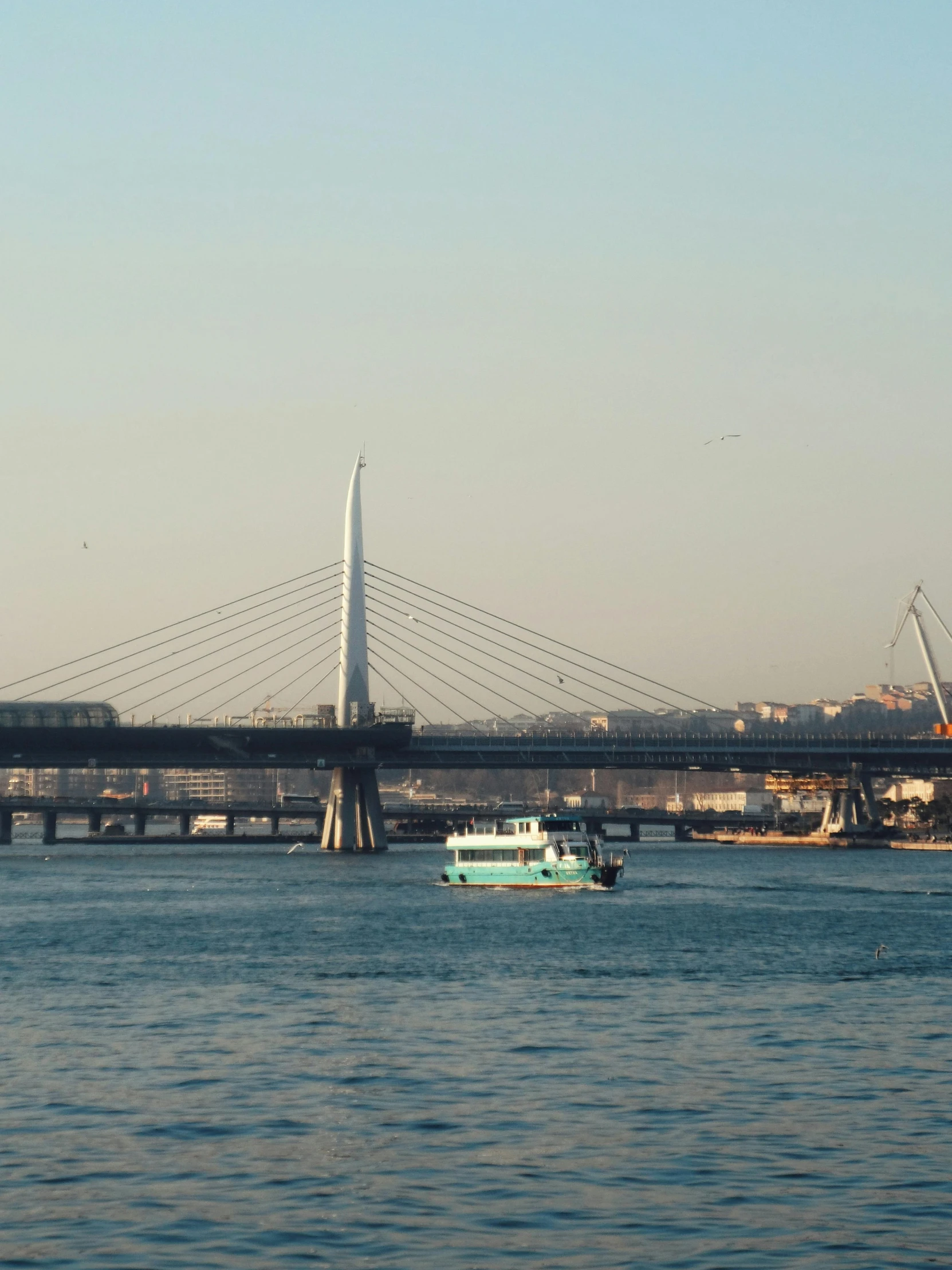 the bridge is above the boat that sits on the water