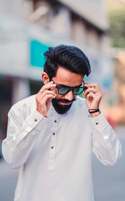 a man with a beard and sunglasses talking on his cell phone