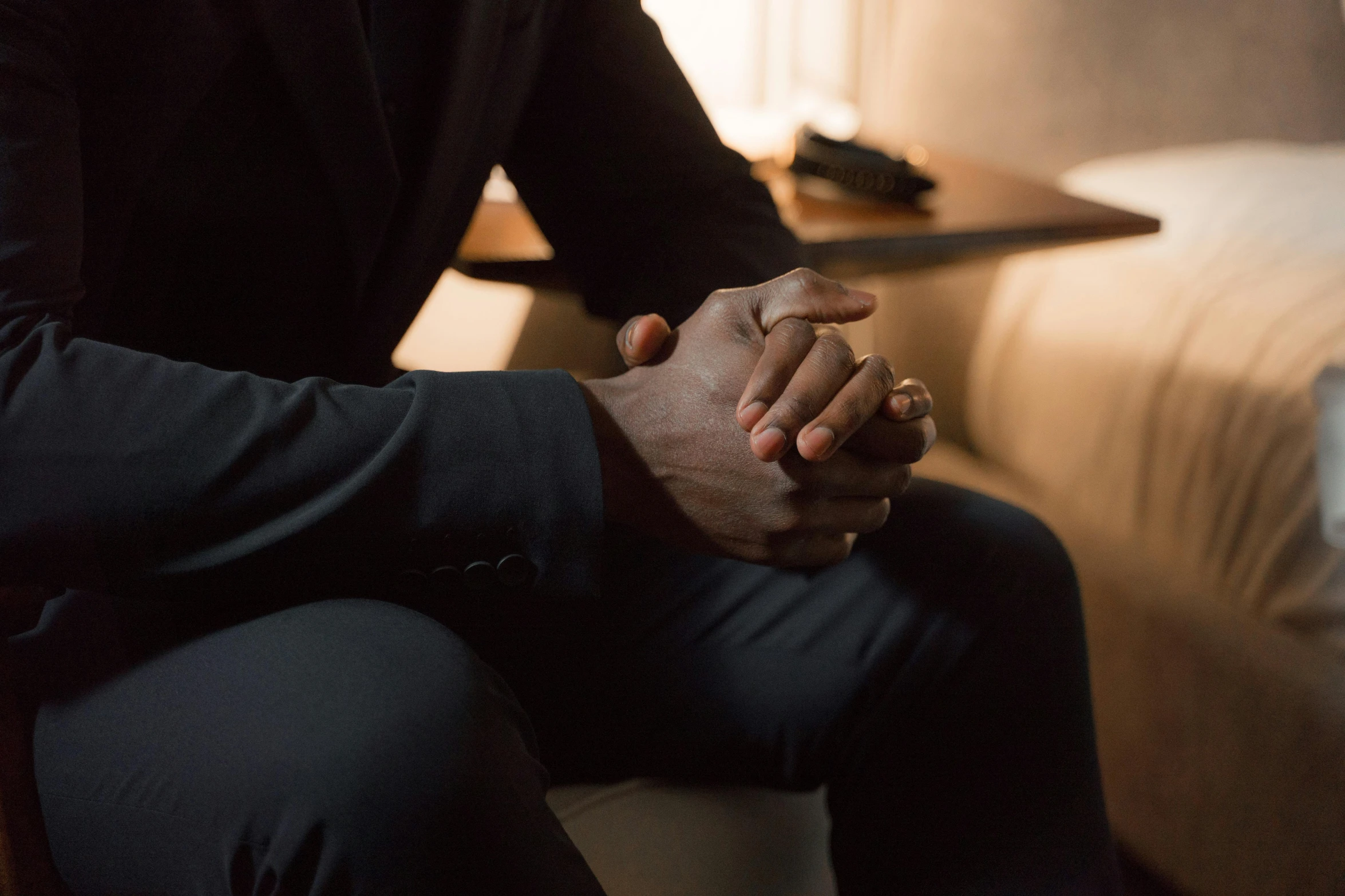 a man holding a person's hand and a lamp near the bed