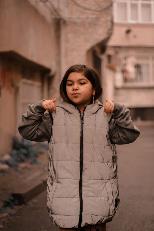 a little girl is posing in front of some buildings