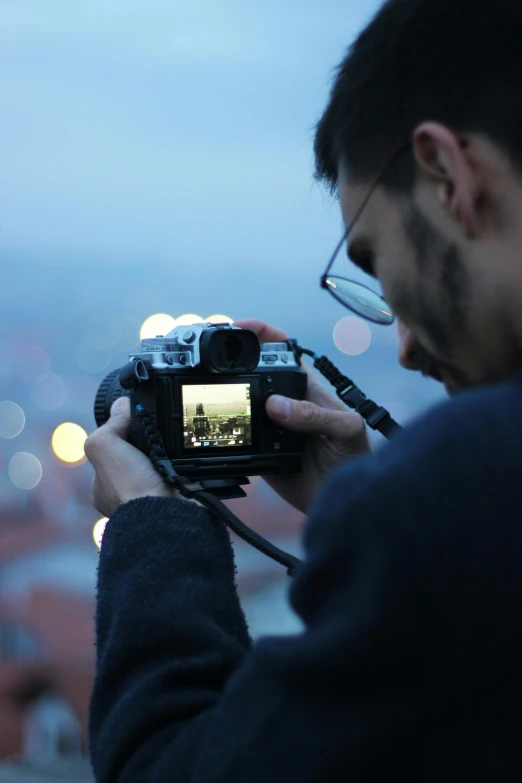 a man looking through a large lens at his camera